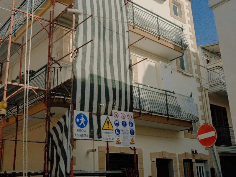 Il fronte della palazzina all'inizio dei lavori, con l'area di cantiere segnalata